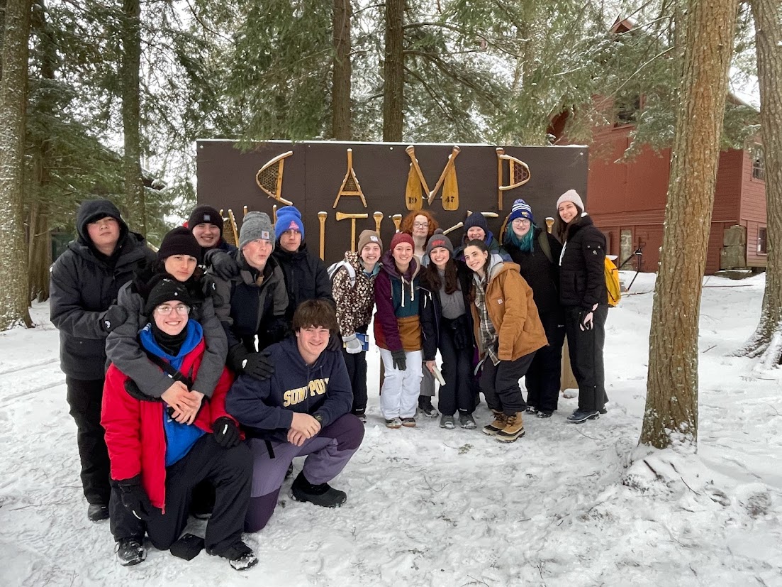 Students Standing in front of Camp Huntingtons welcome sign- Winter 2024