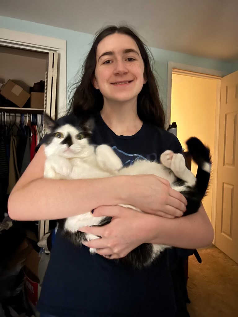 Leah Brown cradling her older cat, Jinx.