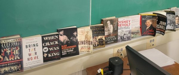 Part of Mr. Jeror's collection of books against his chalkboard.