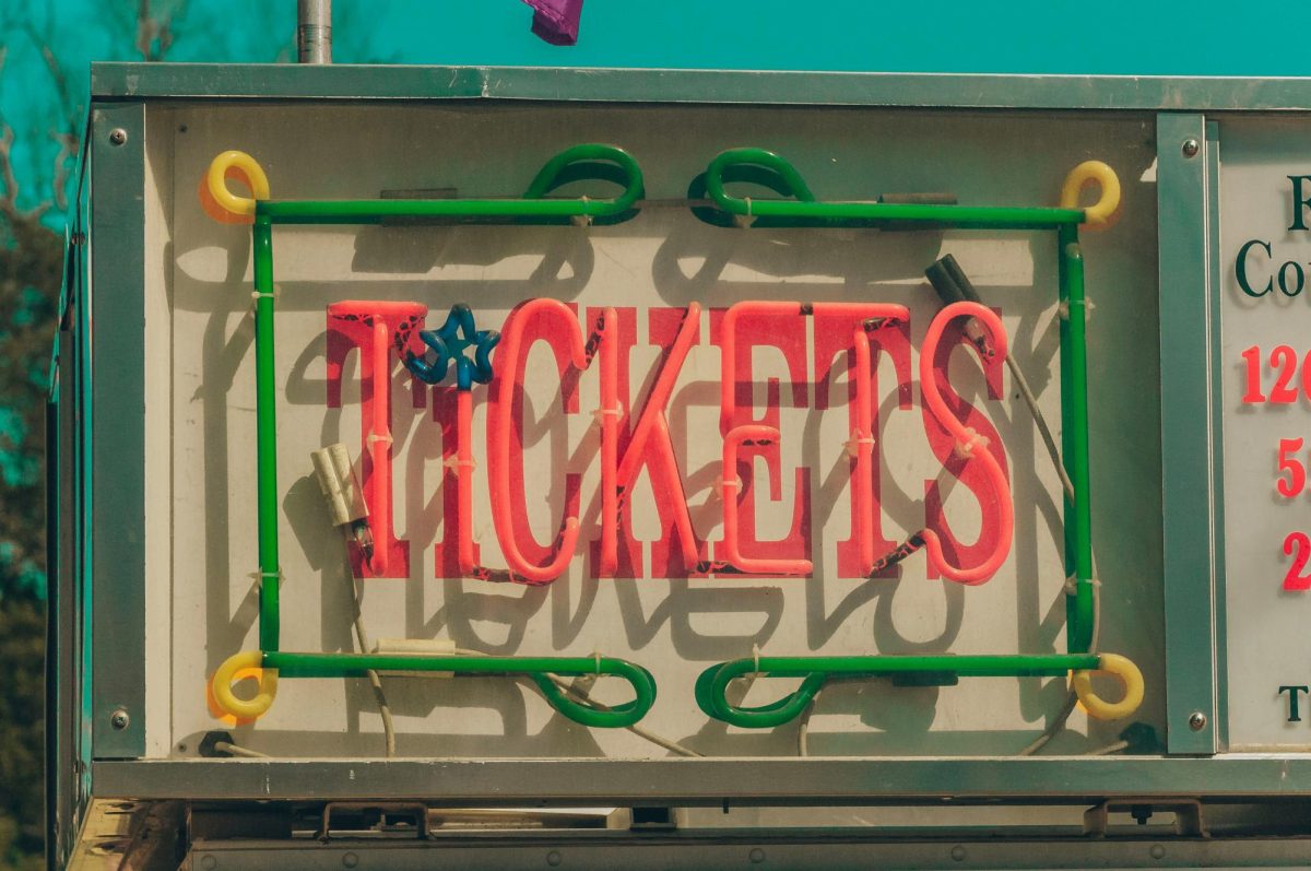 Neon sign that says tickets on the side of a building.