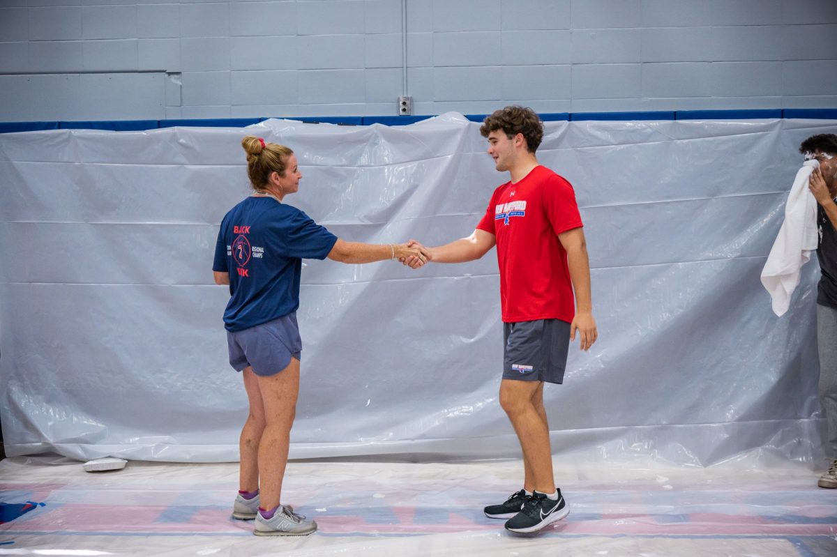 Mrs. Randall and Sam Beaton shake hands at the pep rally.  Fall 2025. 